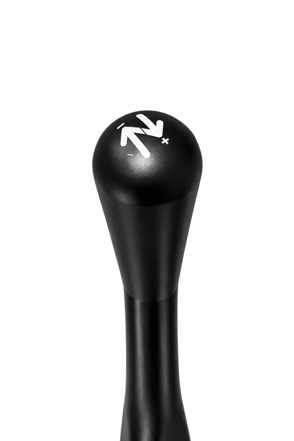 Black gear shift knob with white plus and minus symbols.
