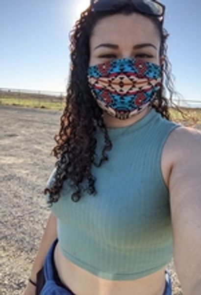 Woman with mask on waking at a park.