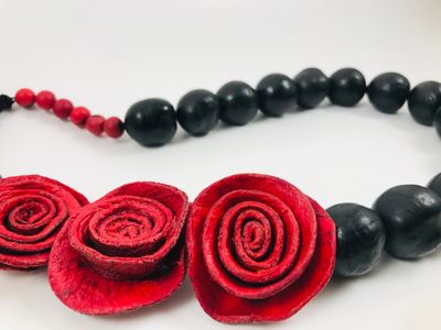 Sustainable handmade necklace. Three citrus peel roses in red with bombona nuts in black. Adjustable
