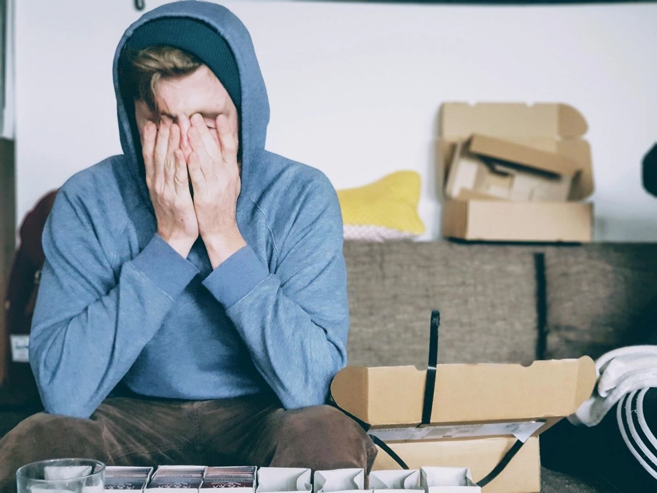 A stressed man sitting with hands on his face A stressed man sitting with hands on his face