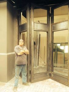 A man posing in front of a door
