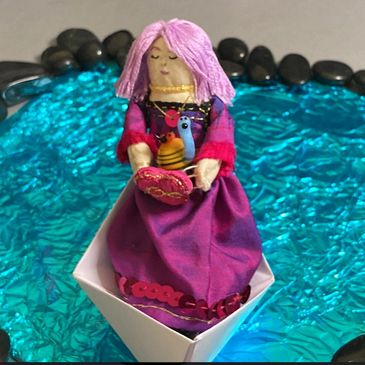 A paper boat on a blue pond holds a girl in a magenta dress. She holds a friendly snail and a heart