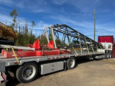 Lattice crane boom sections strapped on a step deck trailer, heavy haul from Panama City, FL