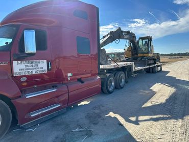 B JR's Transporting red semi hauling a yellow excavator on a step deck trailer, Panama City, FL