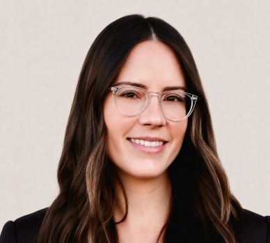 Smiling woman with glasses and long hair.