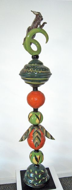 Green and orange beads with a brown rabbit leaping through a spiral bead
