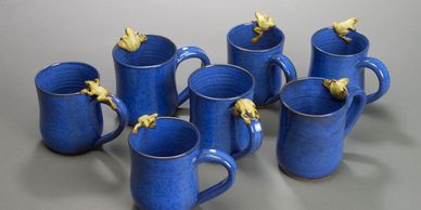 group of mugs with frogs on rims