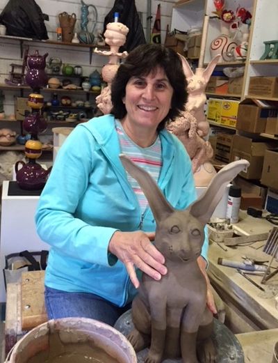 Photo of Alexis Moyer working on a rabbit sculpture
