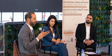 Three professionals engaged in a discussion at a business event.