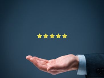 Hand presenting five golden stars on a dark blue background.