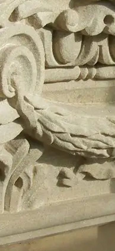 Intricately carved stone architectural capital with classical motifs.