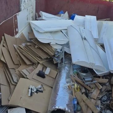 A pile of discarded cardboard and debris in a dumpster.