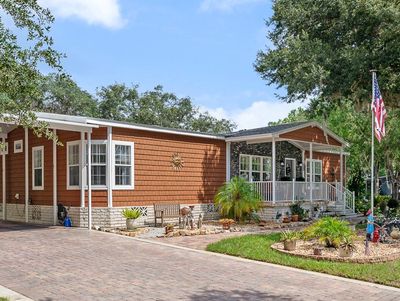 Cozy brown house with a porch and driveway.