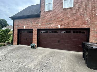Modern woodgrain garage doors with windows and decorative hardware installed in Forsyth County, GA b