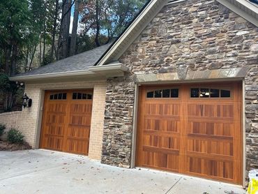 Stamped cedar wood-look garage doors with windows installed in Gainesville, GA by BB Garage Doors.