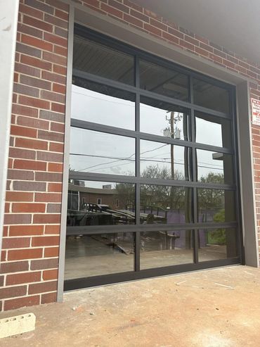Full-view glass garage door with black aluminum frame installed in Alpharetta, GA by BB Garage Doors