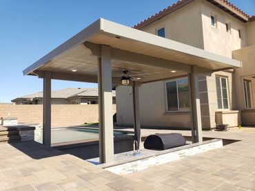 Modern backyard patio with a covered grilling area and pool.
