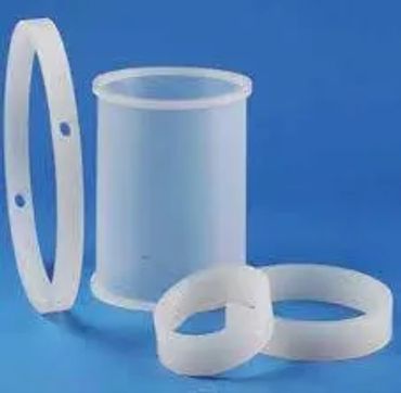 White plastic cylindrical containers and rings on a blue background.