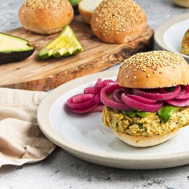 Veggie burger with pickled onions on a sesame bun.