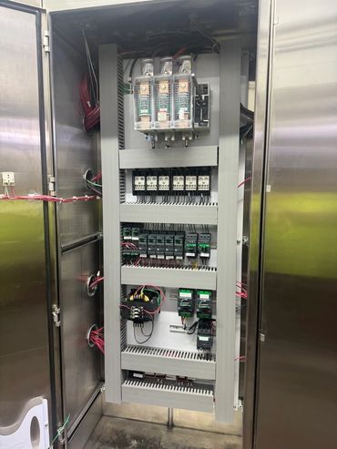 Open electrical control panel with organized wiring and components.