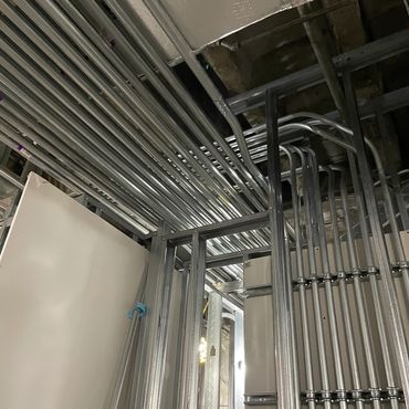 Metal conduit pipes neatly arranged inside a building under construction.