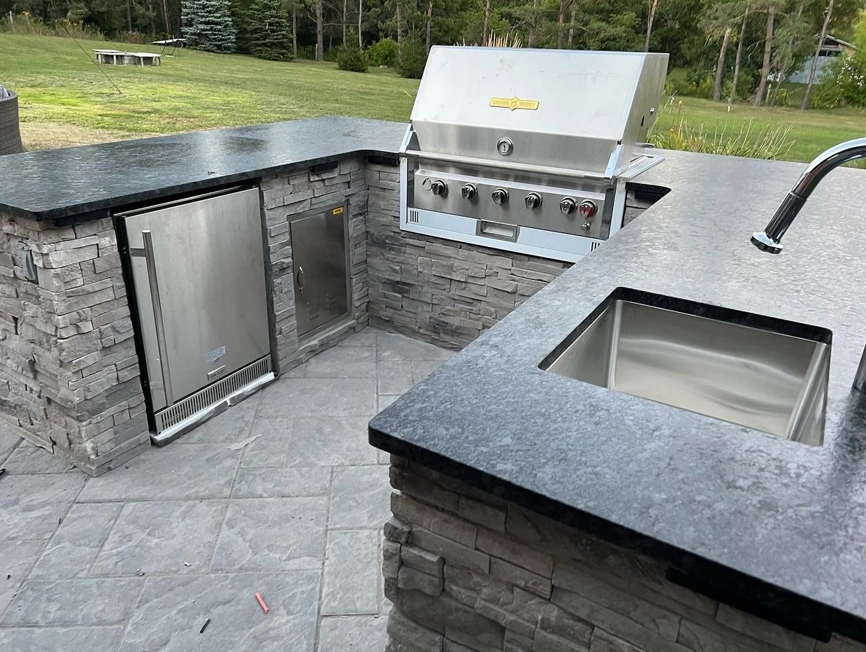 custom outdoor kitchen in Aurora by king renovate, framed with steel frame, finished by stone veneer