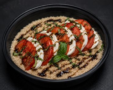 Freshly sliced tomatoes, single between fresh mozzarella on top of savory oatmeal with a balsamic gl
