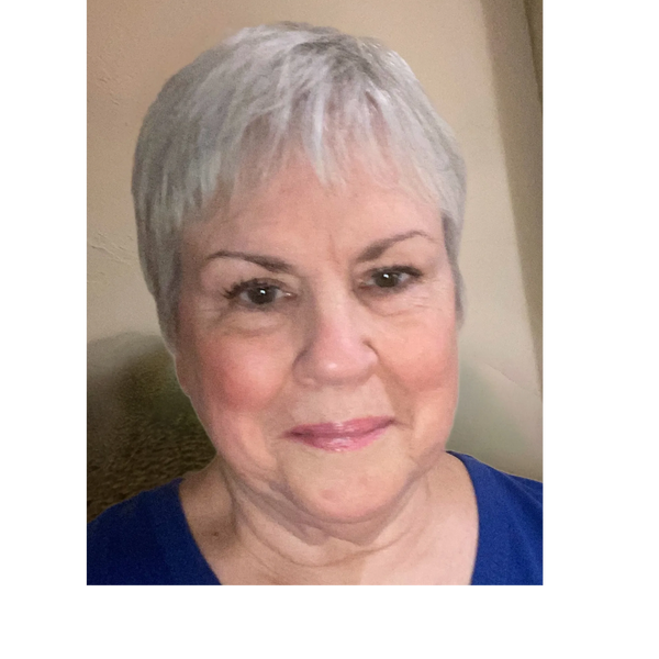 Portrait of a smiling elderly woman with short gray hair wearing a blue top.