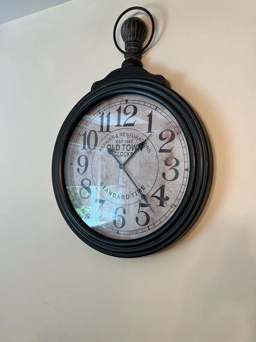 Vintage-style wall clock with black frame and large numbers.