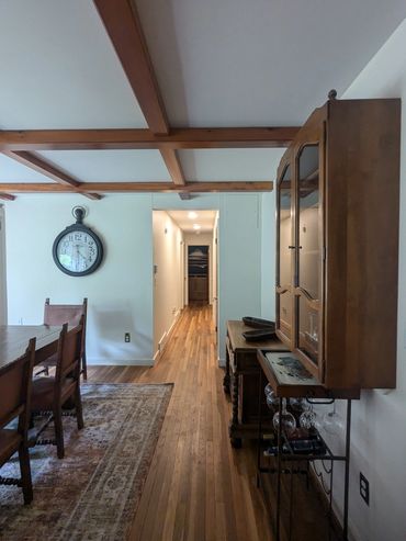 Cozy dining area with wooden furniture and ceiling beams.