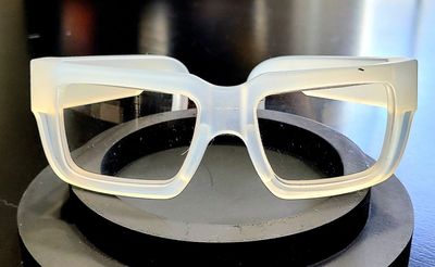 Transparent oversized fashion glasses on black surface.