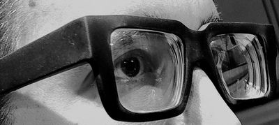 Close-up of eyes behind thick black glasses.