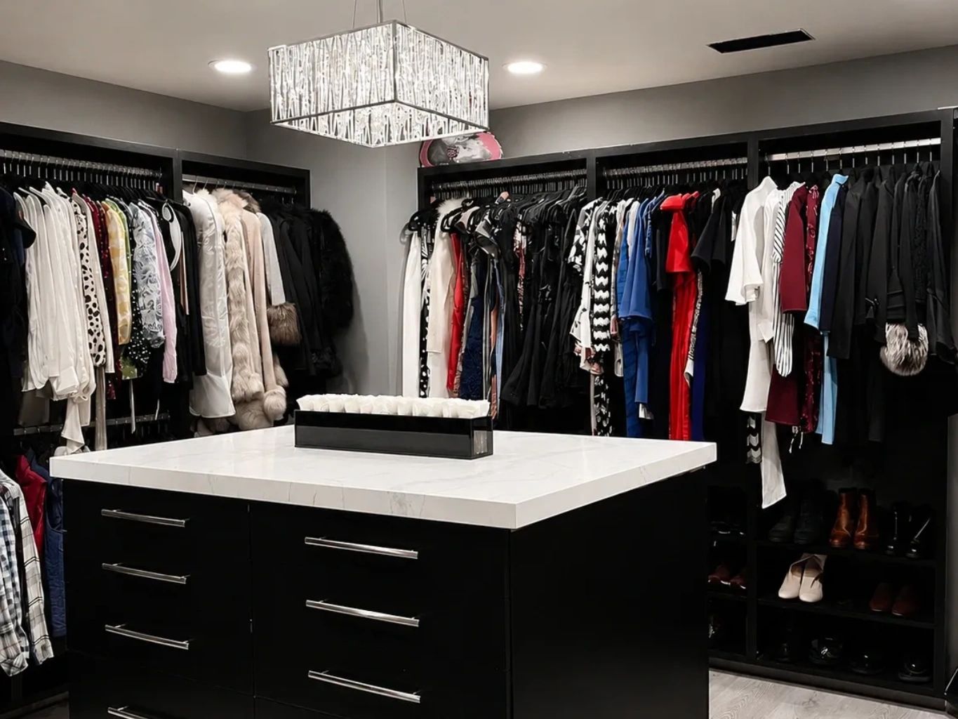 Organized walk-in closet with a black dresser and hanging clothes.