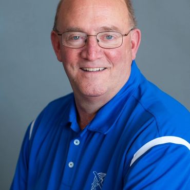 headshot of a man in blue color t shirt
