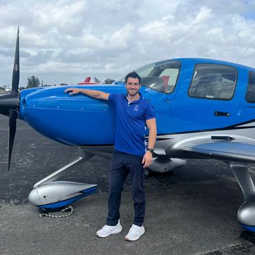 a man in blue t shirt posing with a plane