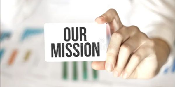 Hand holding a card with the words 'OUR MISSION' in bold letters.