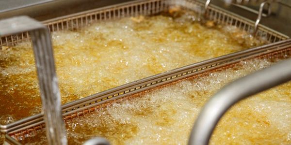 Deep fryer baskets bubbling with hot oil.