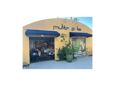 Exterior view of Mutropolis pet store with blue awnings and plants.