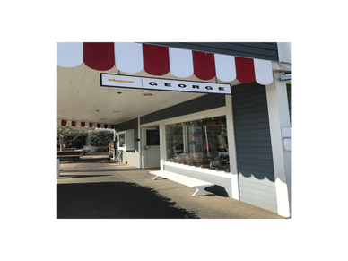 Storefront of George with red and white awning on a sunny day.