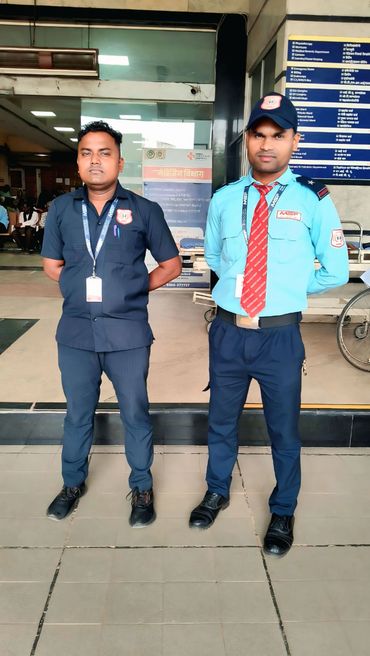 Two security guards standing at a hospital entrance.