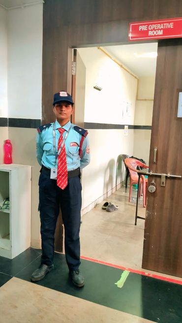 Security guard standing at the entrance of a pre-operative room.