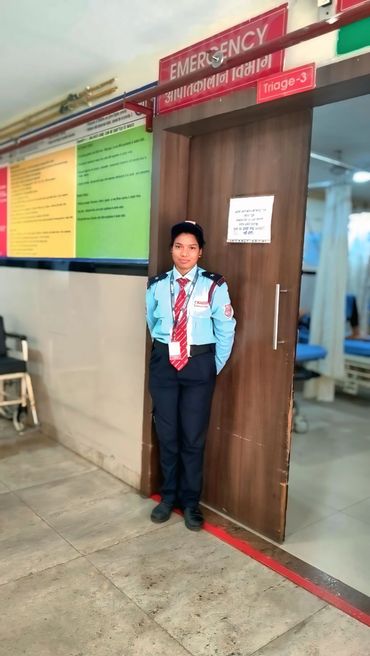 Security guard standing at the emergency triage entrance in a hospital.