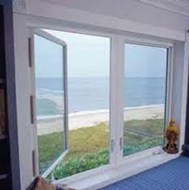 Open window showing a serene beach and ocean view.