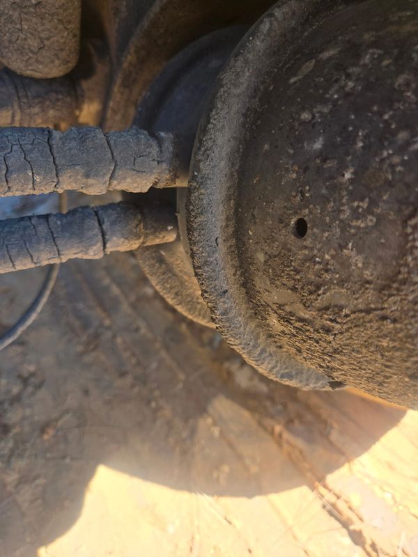 Close-up of cracked, weathered pipes connected to a corroded metal component.