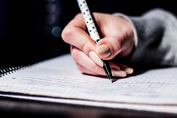 An Image of a Hand with pen - writing
