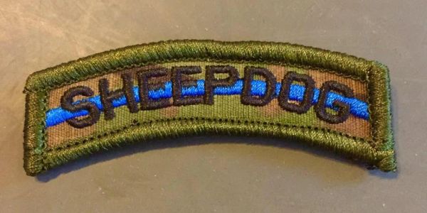 Military patch with 'SHEEPDOG' text.