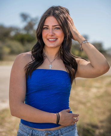 Girl in blue tube top touching her hair