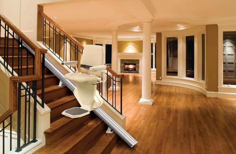 Stair lift installed on staircase in elderly person's home.