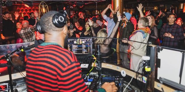 DJ playing music at a crowded club with people dancing.