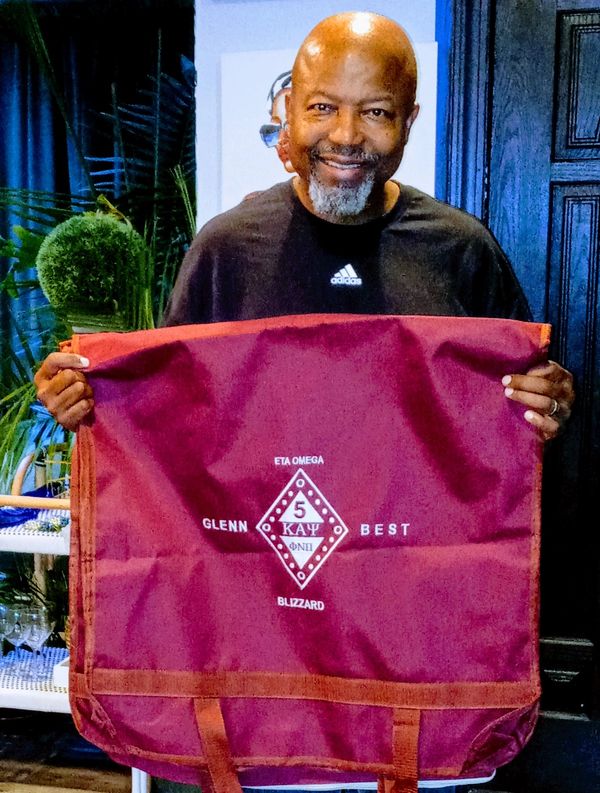 A man holding wine color bag posing